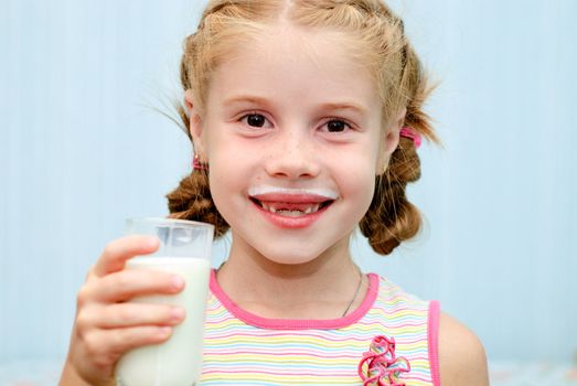 Portrait of a little toothless girl a glass of milk