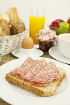 tasty breakfast with salami toast on wooden background