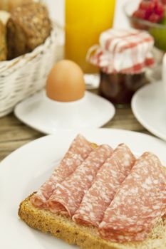 tasty breakfast with salami toast on wooden background