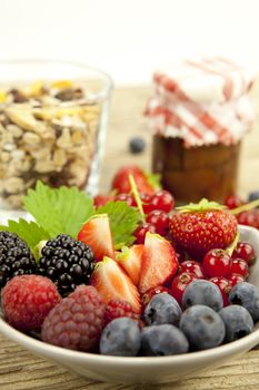 mixed fresh berries for dessert on wooden background in summer