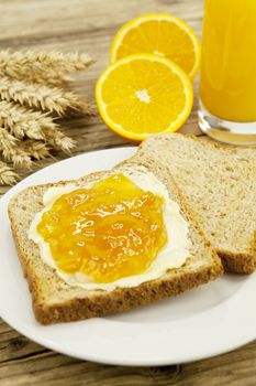 tasty breackfast with toast and marmelade on wooden background