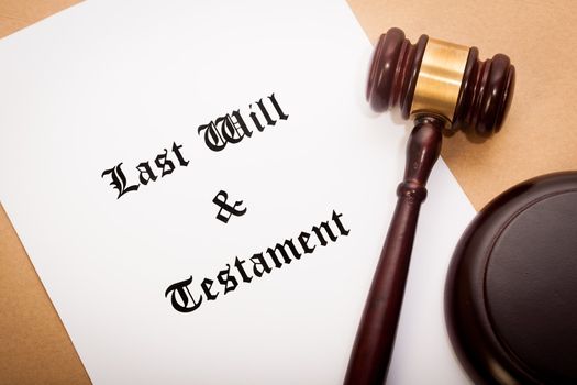 A gavel and soundboard on top of a "Last Will and Testament" contract, with a antique-like background.