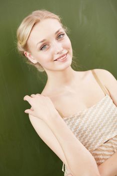 Young female teacher standing near blackboard at school