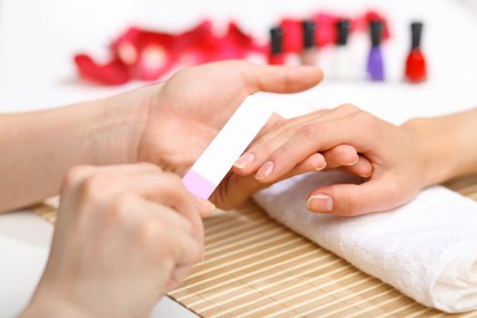 Young woman is getting manicure in a beauty salon