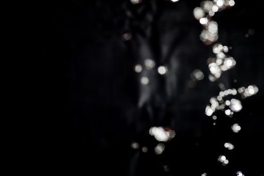 Photo of bokeh water splash black background with copy space