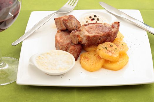 dish of sirloin steak with green peppercorn sauce and Roquefort cheese accompanied by potatoes bakers and glass of wine