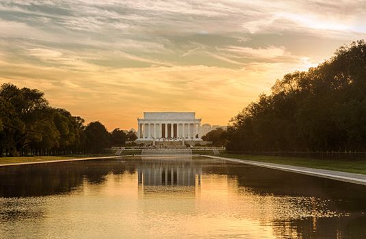 Setting sun illuminates Jefferson Memorial in Washington DC with reflections in new Reflecting Pool