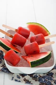 watermelon popsicle in a white bowl with ice and fresch watermelon