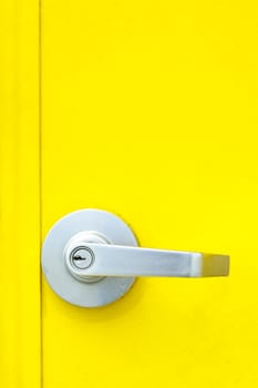 Aluminum door knob on the yellow door.