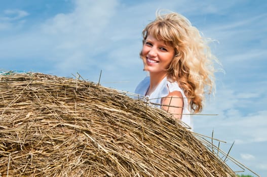 girl lying on a haystack and smiling