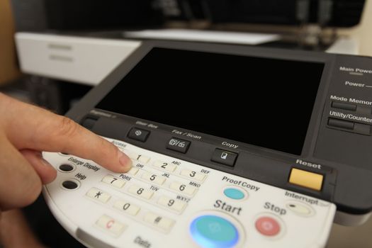 details Finger pressing of keyboard buttons of the laser copier