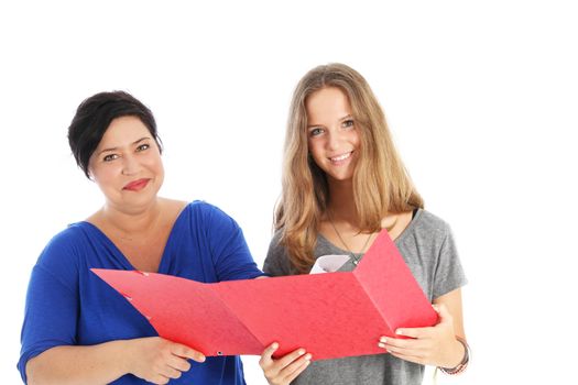 Smiling young female student holding a large red open folder standing with her mother or teacher discussing her assignement isolated on white 