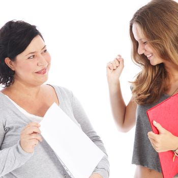 A middle-aged teacher holds up a blank sheet of paper showing a young female student her successful results A middle-aged teacher holds up a blank sheet of paper showing a young female student her results 