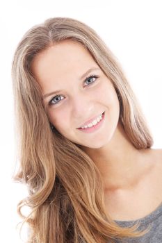 Pretty friendly teenager with her head slightly tilted smiling happily at the camera isolated on white 
