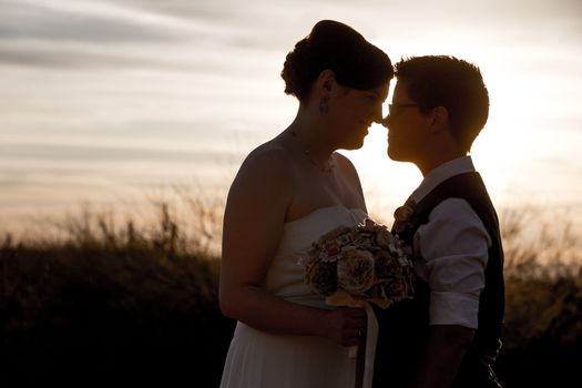 Happy married homosexual couple outdoors at sunrise