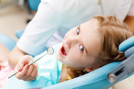 Little girl sitting in the dentists office