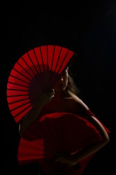 Flamenco artist from behind her red folding fans