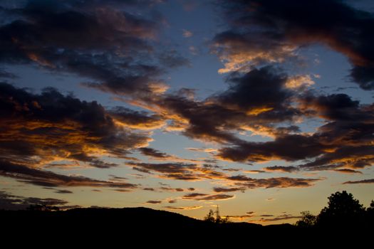 Cloudy sky during sunset in orange and blue