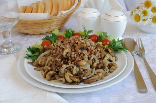 Buckwheat porridge with mushrooms and onions on the dining table