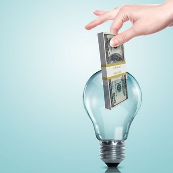 Hand and money inside an electric light bulb