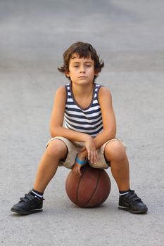 Young cute boy with basketball ball