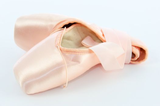 A pair light or pale pink ballet point shoes or slippers isolated on a white background