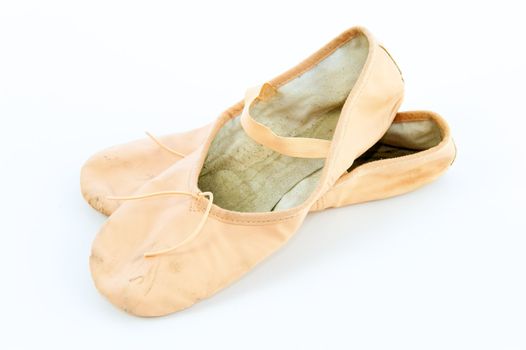 A pair light or pale pink ballet slippers isolated on a white background with a lot of copyspace