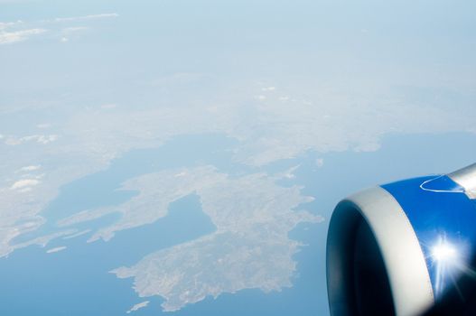 airplane wing, turbine, sky and clouds as seen through the cabin window