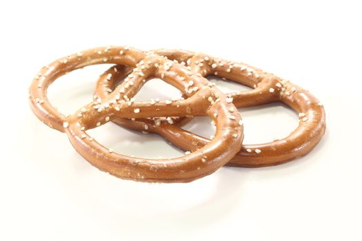 two Bavarian pretzels with salt on a bright background