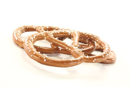 three Bavarian pretzels with salt on a bright background