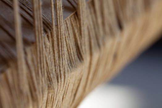 Close-up detail on the old loom - large fluffy yarn photographed from the side with a shallow depth of field