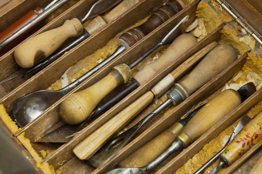 Tools professional woodcarver. Lie in a wooden tray of chips. Close-up.