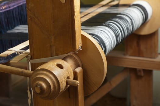 Old wooden loom in weaving - side view. Illuminated by soft light overhead. Close-up