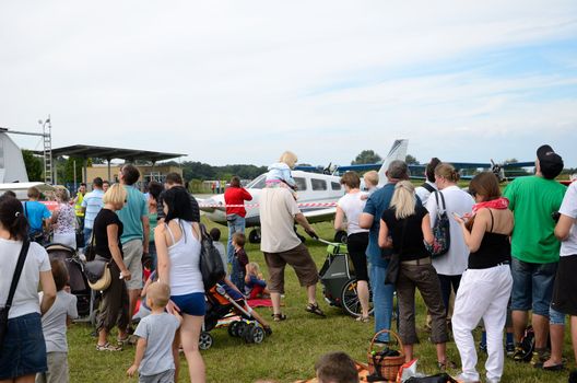 SZYMANOW, POLAND - AUGUST 25: Unidentified group of people admires planes during air show on August 25, 2012 in Szymanow.