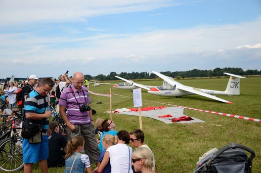 SZYMANOW, POLAND - AUGUST 25: Unidentified group of people admires planes during air show on August 25, 2012 in Szymanow.