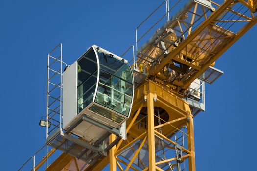 Cab modern construction crane on a background of blue sky