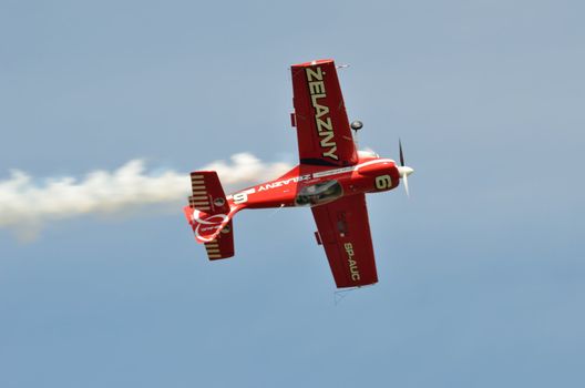 SZYMANOW, POLAND - AUGUST 25: Pilot Tadeusz Kolaszewski performs acrobatic show in plane Zlin-50 LS on August 25, 2012 in Szymanow.