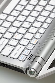 Silver laptop in the open form, a fragment of the keyboard