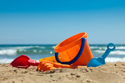 Children's beach toys - buckets, spade and shovel on sand on a sunny day