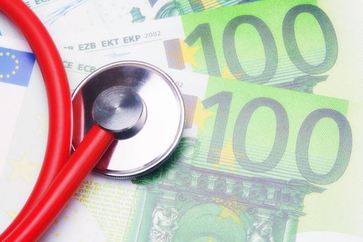 Red stethoscope close-up on top of Euro banknotes