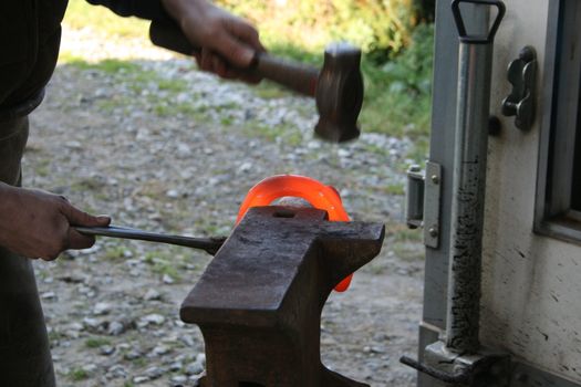 Blacksmith at work while changing a horseshoe