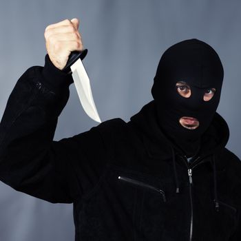 black dressed man with a knife in studio