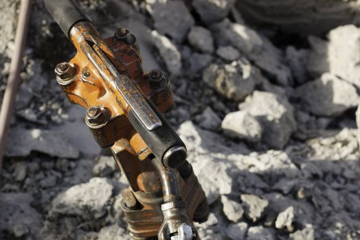 jack hammer used for breaking, chipping, and demolishing concrete with shallow dof and broken concrete in background