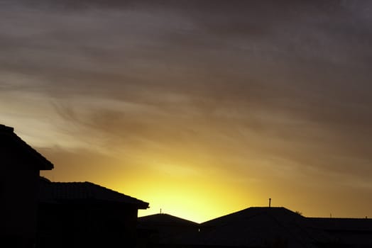 bright orange western sunset over houses