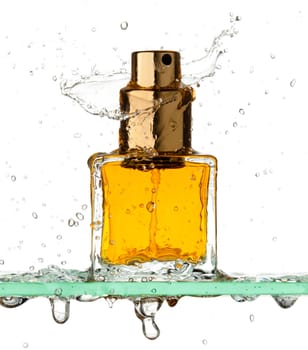 Small rectangular bottle of perfume all in a spray of water on a white background