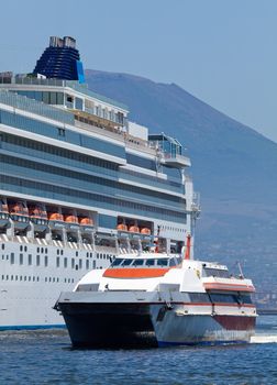 Passenger catamaran and a large cruise ship in the port of Naples