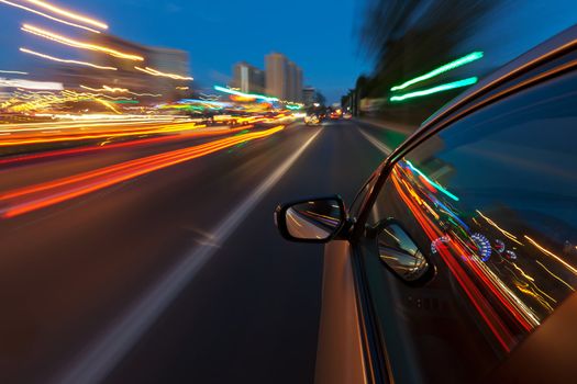 Cars driving through the city with such speed that the lights of the city reserves the long tracks