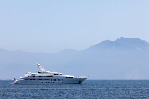 Large white motor yacht anchored in the bay mountain