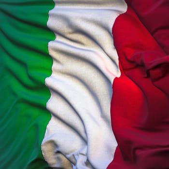 Flag of Italy, fluttering in the breeze, backlit rising sun. Sewn from pieces of cloth, a very realistic detailed state flag with the texture of fabric fluttering in the breeze, backlit by the rising sun light