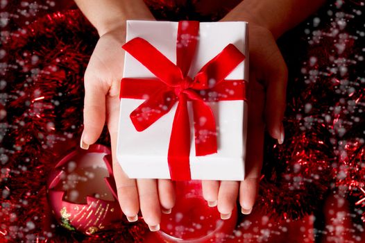 Woman hands holding red Christmas gift